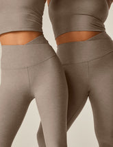 brown high-waisted midi leggings with a front crossover waistband.
